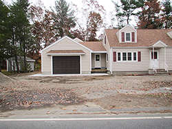 cape style house with attached garage and porch